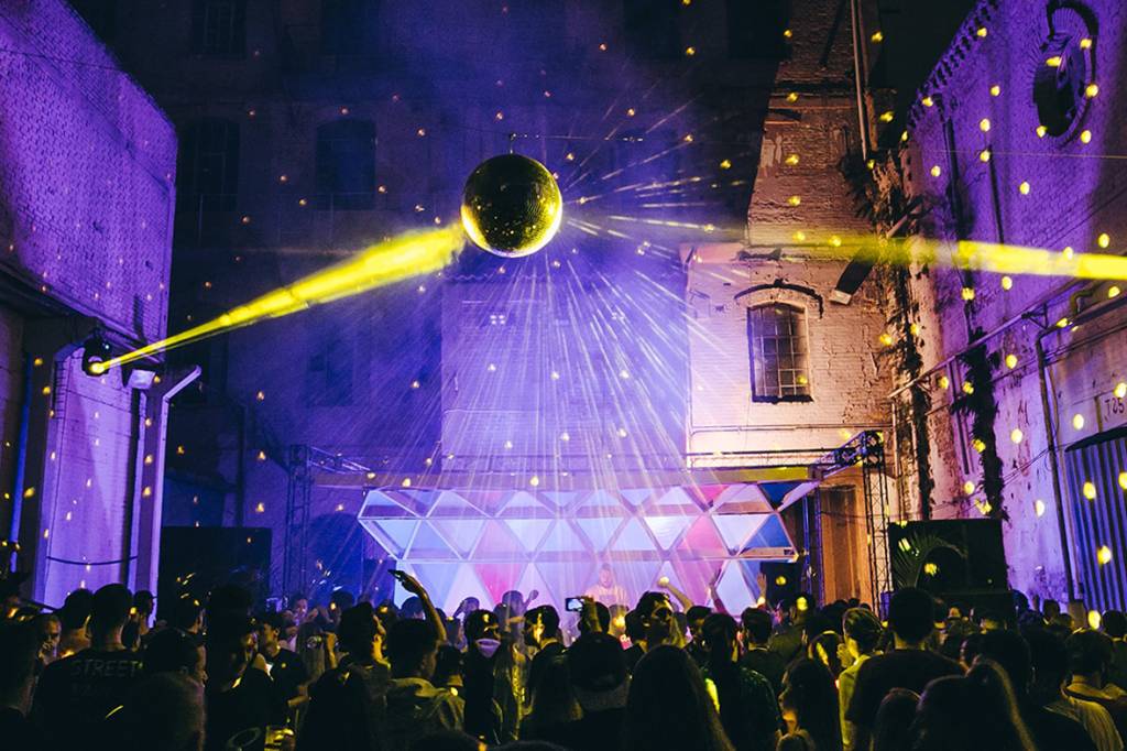 fotografia da uma edição da GOPTUN com globo de luz e luzes amarelas e roxas